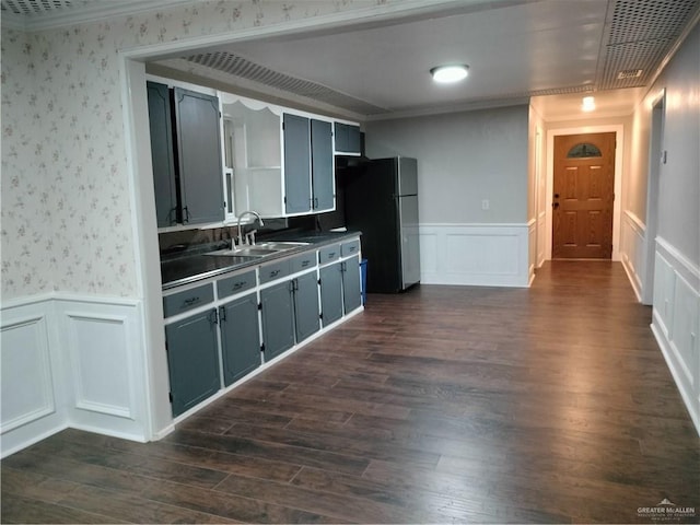 9458 Charles Green Rd, Edcouch, TX 78538 - kitchen with freestanding refrigerator, ornamental molding, wainscoting, wallpapered walls, and a decorative wall