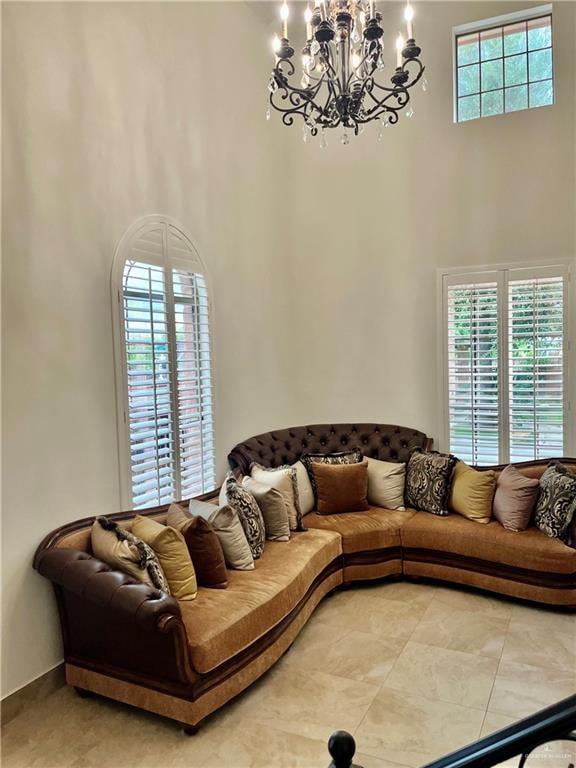 living room with a chandelier, a high ceiling, and a wealth of natural light