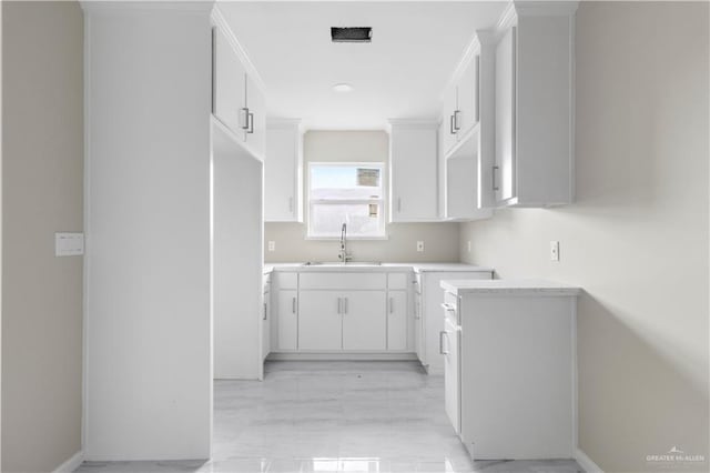 kitchen featuring sink and white cabinets