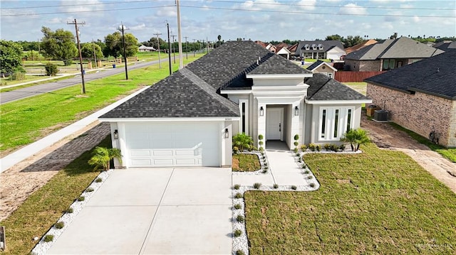 view of front of property featuring central AC unit, a garage, and a front lawn