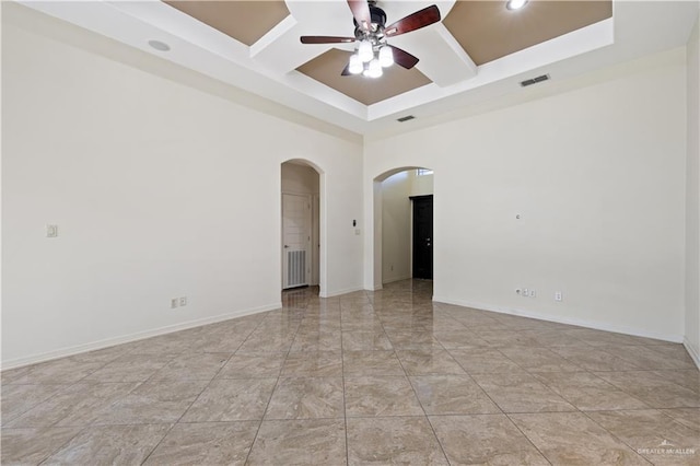 empty room with visible vents, baseboards, ceiling fan, arched walkways, and coffered ceiling