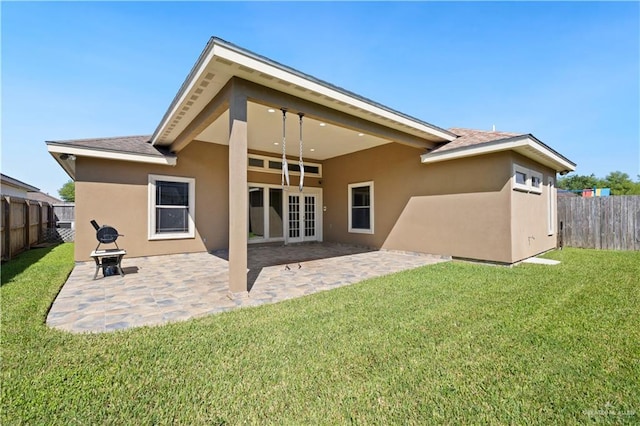 back of house featuring stucco siding, a fenced backyard, french doors, and a yard