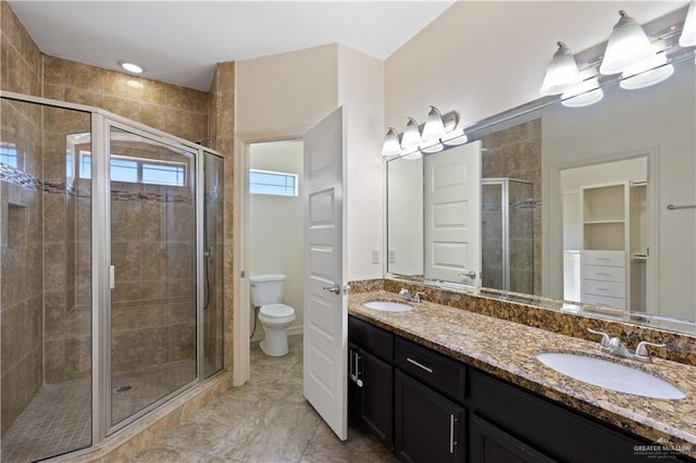 full bath with toilet, a sink, and a stall shower