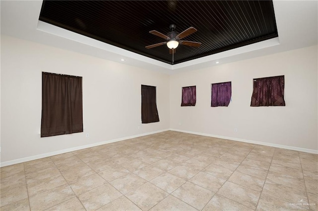 spare room featuring a raised ceiling, ceiling fan, and wooden ceiling