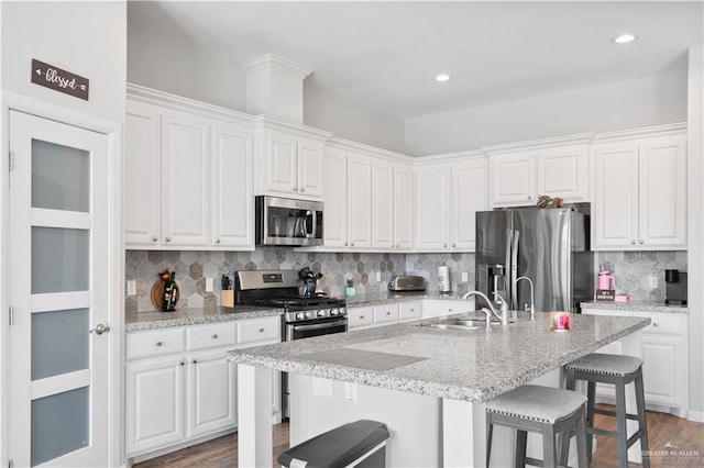 kitchen featuring white cabinetry, a breakfast bar, and stainless steel appliances