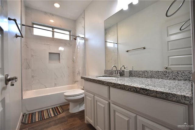 full bathroom featuring vanity, hardwood / wood-style flooring, toilet, and tiled shower / bath