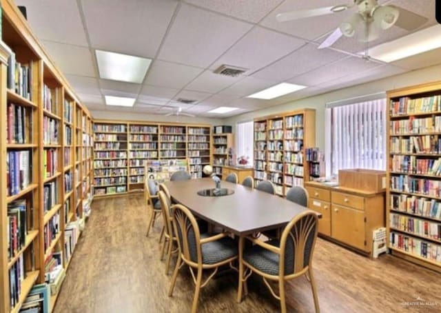 dining area with light hardwood / wood-style floors, a drop ceiling, and ceiling fan