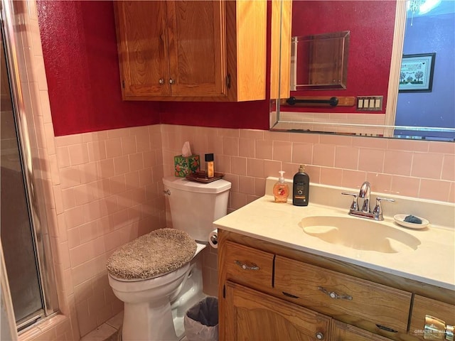 bathroom featuring toilet, vanity, tile walls, and an enclosed shower