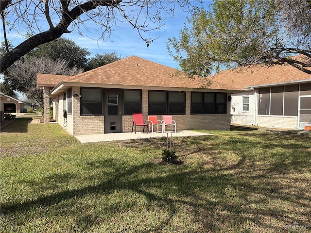 back of house featuring a patio area, a yard, and a sunroom