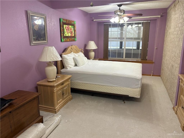 carpeted bedroom with ceiling fan and a textured ceiling