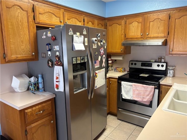 kitchen with sink, appliances with stainless steel finishes, exhaust hood, and light tile patterned flooring