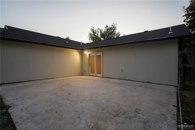 back house at dusk featuring a patio area