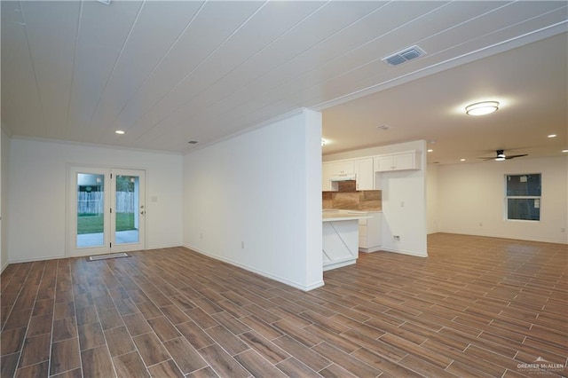 unfurnished living room featuring ceiling fan, crown molding, and hardwood / wood-style flooring