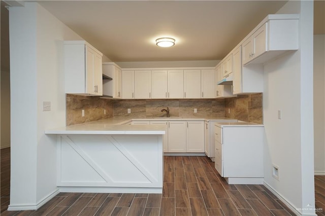 kitchen with backsplash, sink, white cabinets, and dark hardwood / wood-style floors