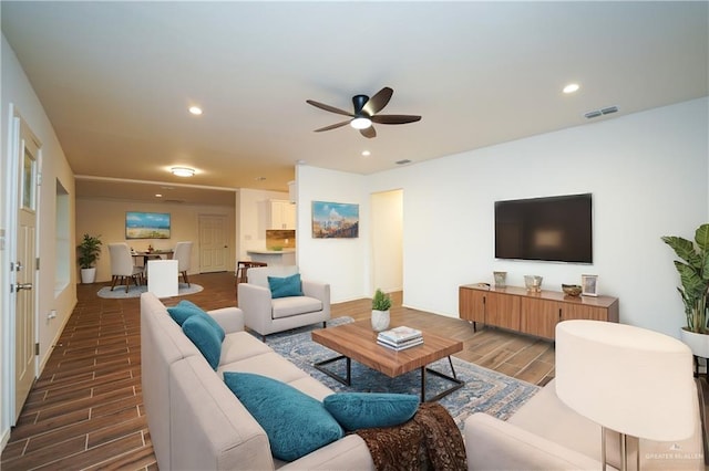 living room featuring ceiling fan and hardwood / wood-style floors