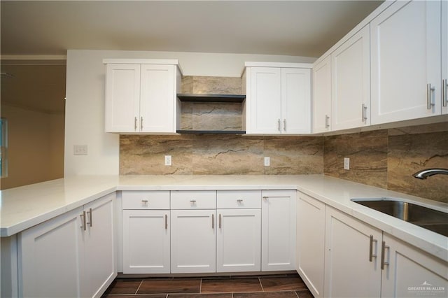 kitchen with white cabinets, decorative backsplash, and kitchen peninsula