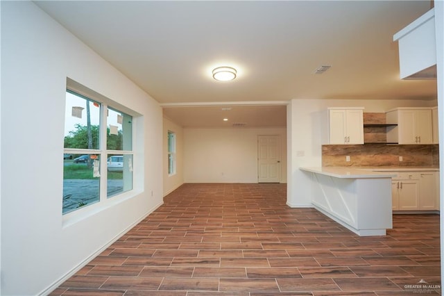 kitchen with white cabinets, backsplash, and light hardwood / wood-style flooring