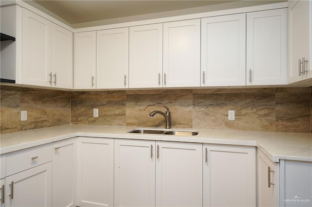 kitchen with white cabinetry, sink, and tasteful backsplash