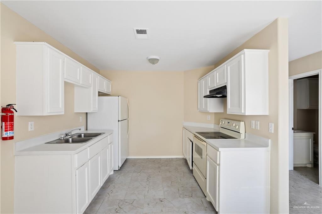 303 Gastel Cir, Edinburg, TX 78539 - kitchen featuring visible vents, under cabinet range hood, light countertops, white appliances, and a sink