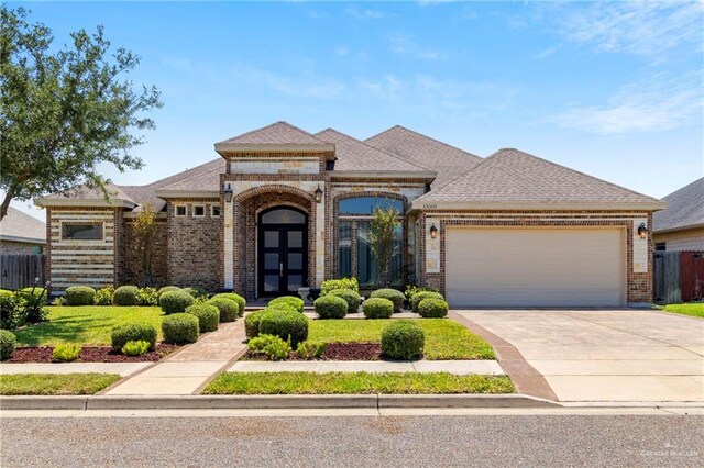 13500 35th St, Edinburg, TX 78541 - french provincial home featuring brick siding, an attached garage, driveway, fence, and a shingled roof