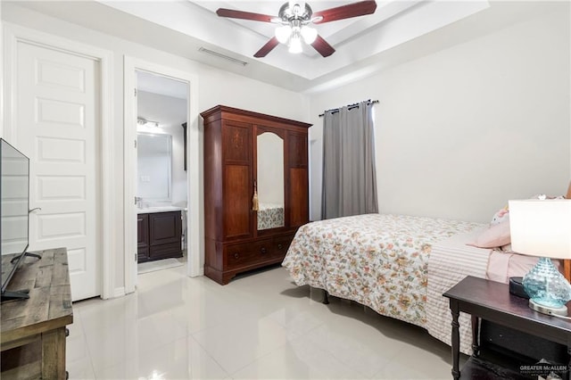 13500 35th St, Edinburg, TX 78541 - bedroom with a tray ceiling, light tile patterned floors, ceiling fan, and connected bathroom