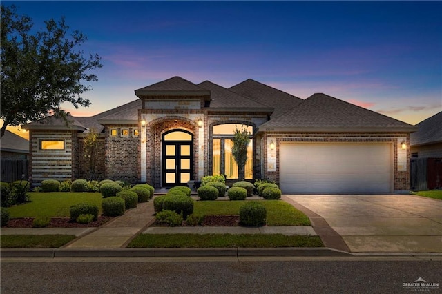 13500 35th St, Edinburg, TX 78541 - french country inspired facade featuring brick siding, a garage, concrete driveway, roof with shingles, and a lawn