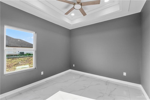 unfurnished room with ceiling fan, recessed lighting, baseboards, marble finish floor, and a tray ceiling