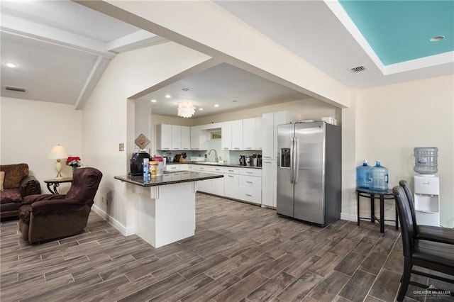 kitchen with sink, kitchen peninsula, stainless steel fridge, dark hardwood / wood-style flooring, and white cabinetry