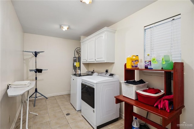 washroom featuring cabinets, separate washer and dryer, light tile patterned floors, and water heater