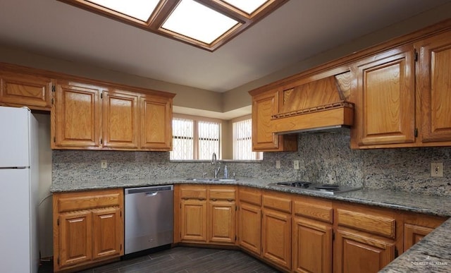 kitchen featuring premium range hood, sink, white refrigerator, stainless steel dishwasher, and gas cooktop