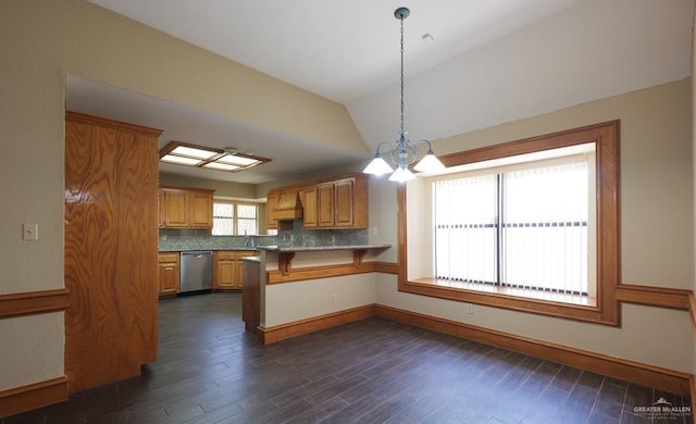 kitchen with decorative light fixtures, tasteful backsplash, dishwasher, lofted ceiling, and kitchen peninsula