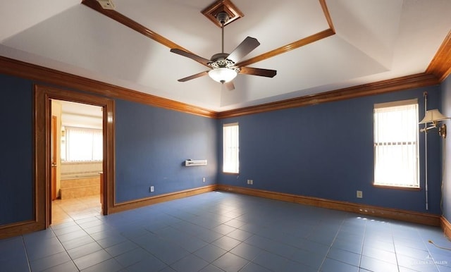 unfurnished room featuring crown molding, a raised ceiling, and a wealth of natural light