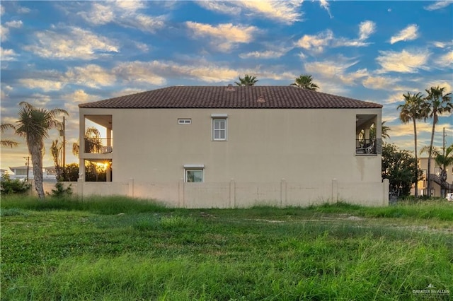 107 E Palm St Unit A, South Padre Island, TX 78597 - view of home's exterior featuring a tile roof, stucco siding, and a balcony