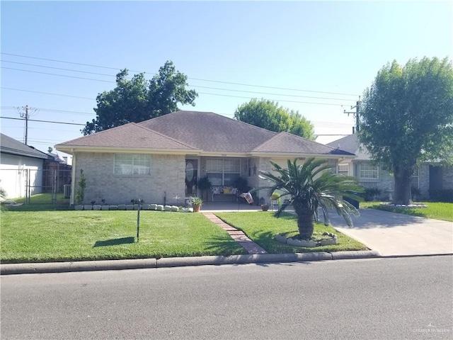 ranch-style house featuring driveway, fence, and a front lawn