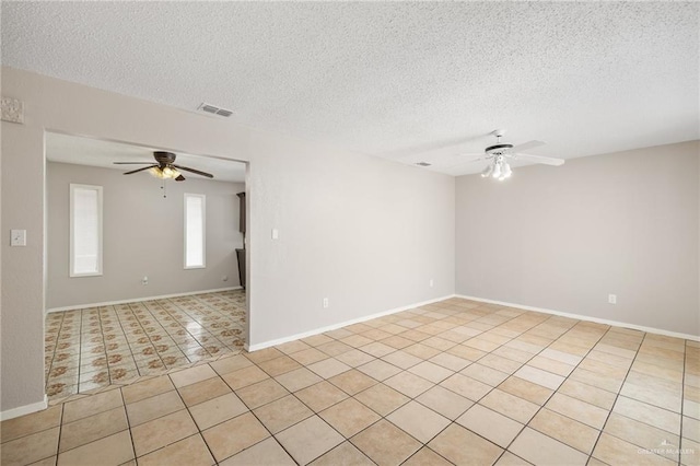 unfurnished room featuring ceiling fan, light tile patterned floors, and a textured ceiling