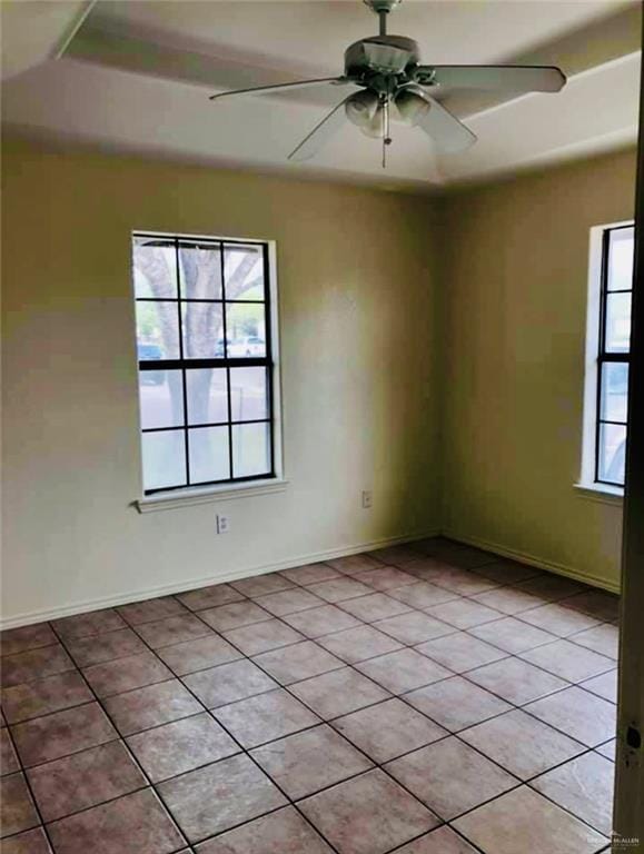 tiled spare room featuring ceiling fan