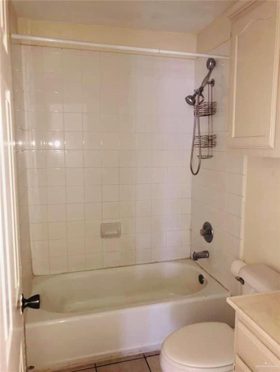 full bathroom featuring tile patterned flooring, vanity, tiled shower / bath combo, and toilet