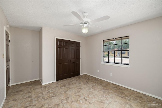 unfurnished bedroom featuring ceiling fan, a closet, and a textured ceiling