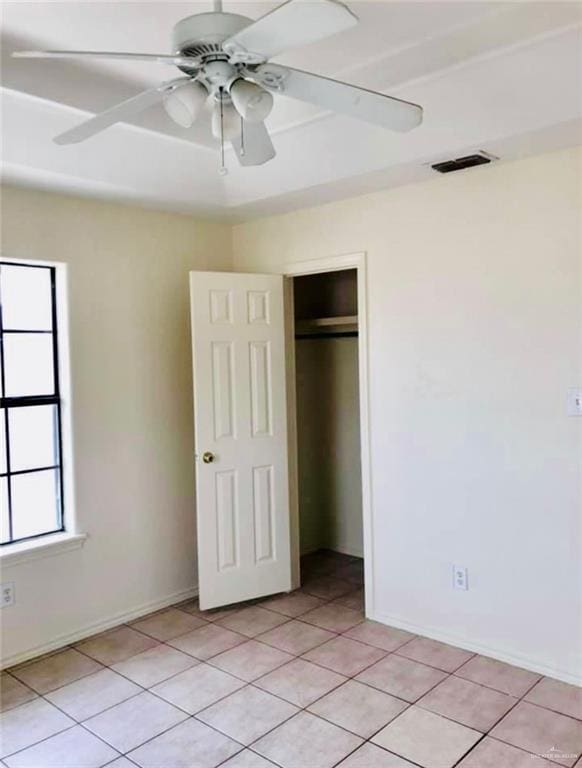 unfurnished bedroom with a closet, ceiling fan, and light tile patterned flooring