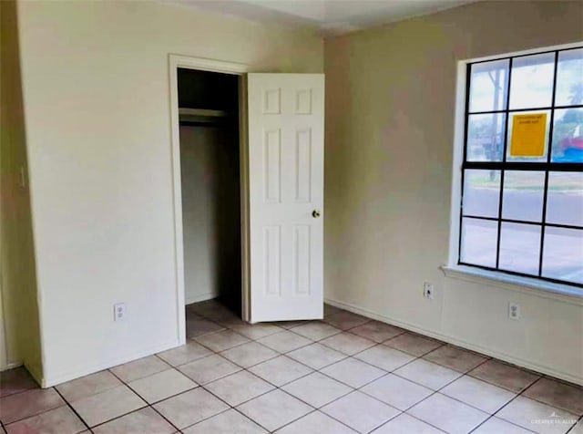 unfurnished bedroom featuring a closet and light tile patterned floors