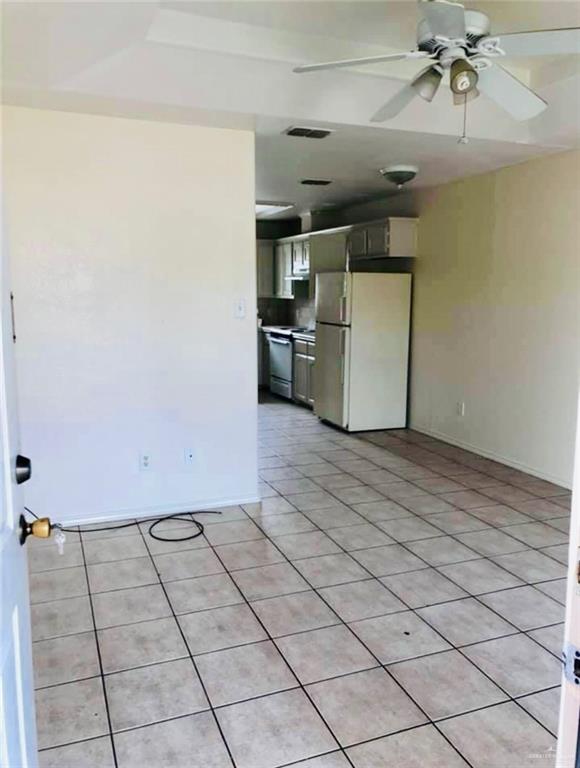 tiled empty room featuring ceiling fan