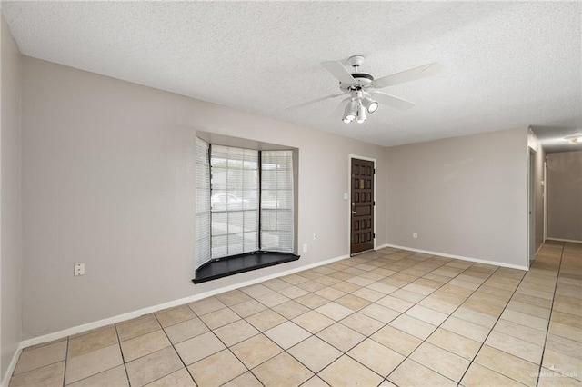 empty room featuring ceiling fan, light tile patterned flooring, and a textured ceiling