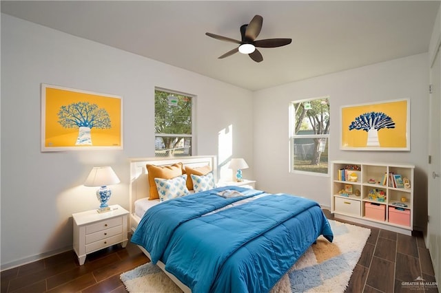 bedroom with dark hardwood / wood-style floors, ceiling fan, and multiple windows