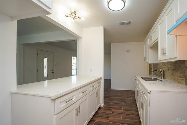 kitchen featuring white cabinets, tasteful backsplash, dark wood-type flooring, and sink