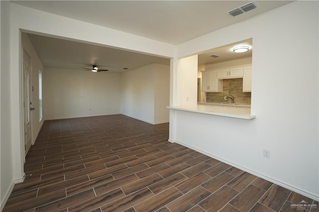 unfurnished living room with ceiling fan and sink