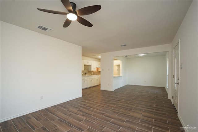 unfurnished living room featuring dark hardwood / wood-style floors and ceiling fan