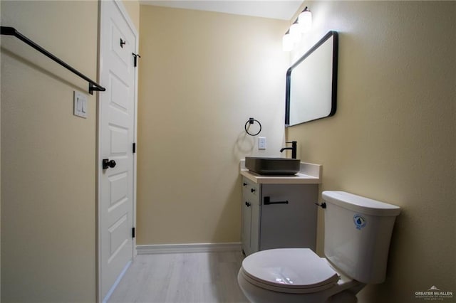 bathroom with vanity, wood-type flooring, and toilet