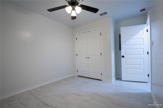 unfurnished bedroom with ceiling fan and a closet