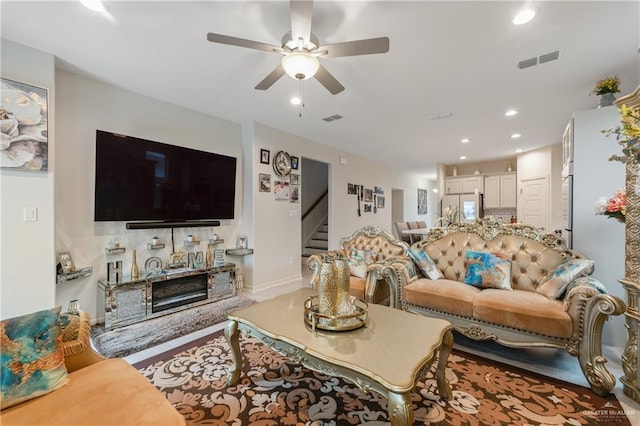 living room with ceiling fan and a fireplace