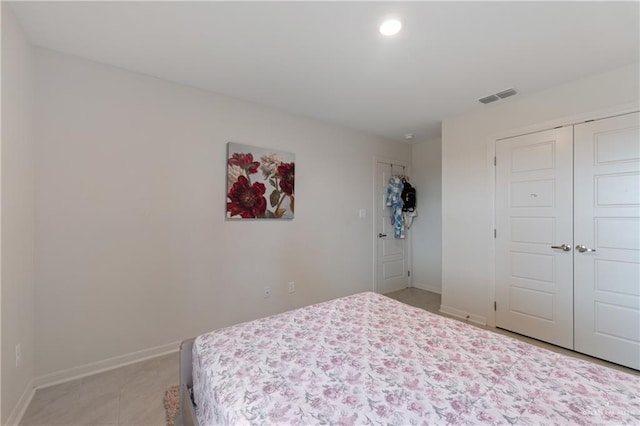 bedroom with a closet and light tile patterned flooring